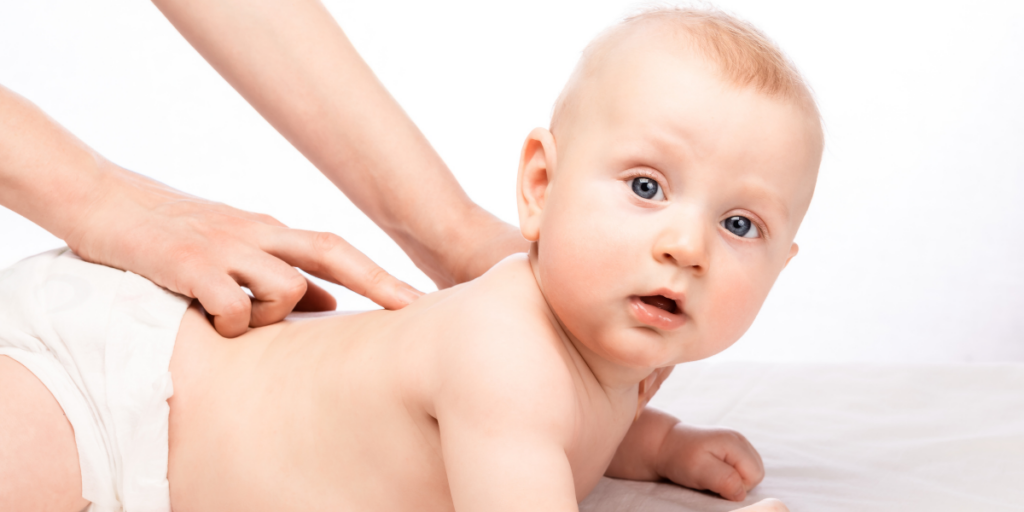 Sarı saçlı, tedavi uygulanmak için yere uzandırılmış bir bebek